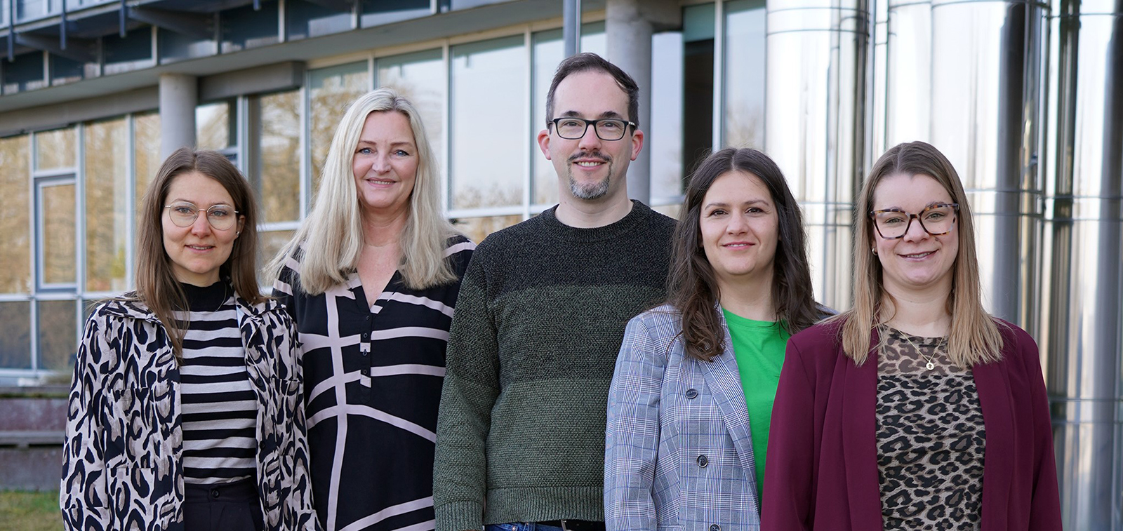 Personalrat der HSAS Fünf Mitglieder des Personalrats stehen nebeneinander vor einem Hochschulgebäude und blicken in die Kamera